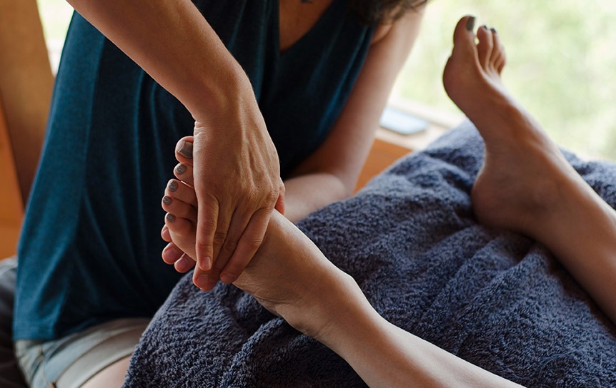 Woman Massaging One Foot With Two Hands