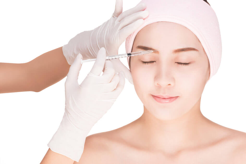 Woman receiving a dermal injection with pink headband