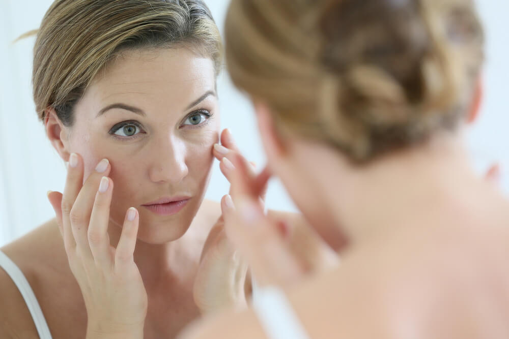 Woman examining facial wrinkles