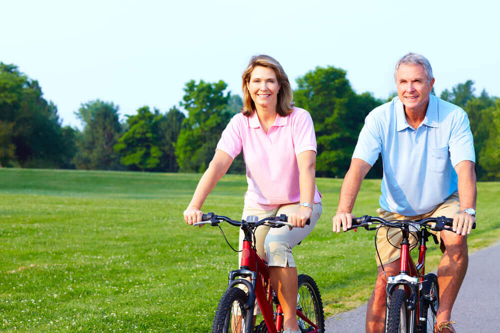 Older couple enjoying a bike ride on a paved path