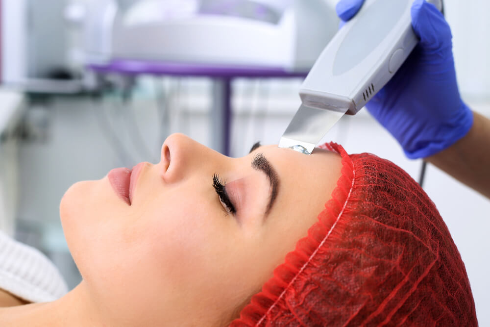 Woman receiving laser treatment on her forehead