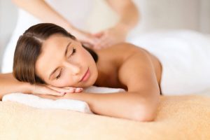 Relaxed woman enjoying a massage from two hands