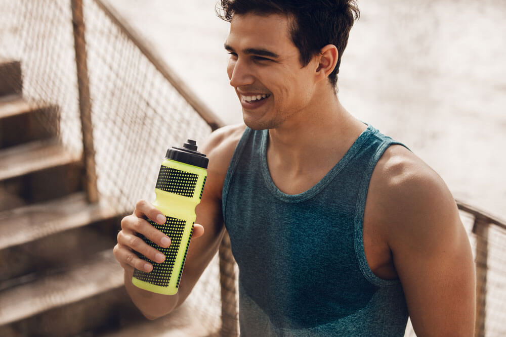 Smiling man working out holding a water bottle