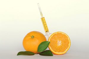 Vitamin Injection surrounded by sliced orange