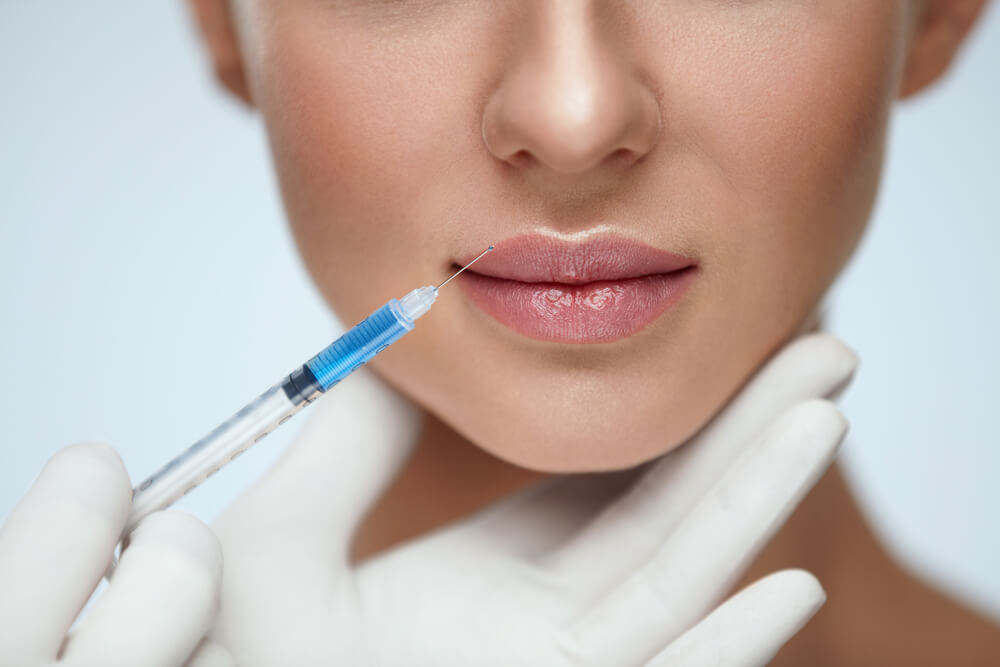 Close Up of Needle Close to a Woman's Lips